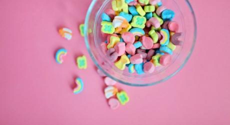 A bowl of rainbow coloured cereal in a clear bowl