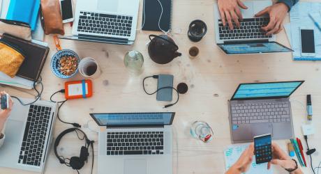 A birds eye view of a busy table of office workers