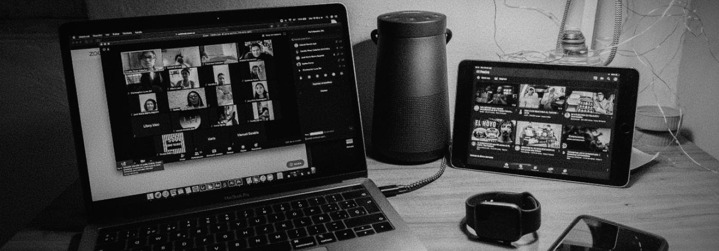 A laptop and tablet showing an online meeting